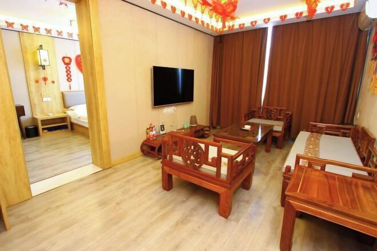 Habitación de hotel con televisión, muebles de madera y una cortina.