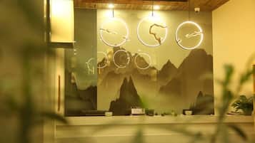 A room with a wooden ceiling, a wall with a mountain mural, and three circular light fixtures.