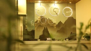Een receptiegedeelte met een bergmuur, ronde lampen en een houten plafond.