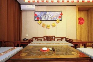 A conference room with a glass table, wooden chairs, a painting on the wall, and a red seal. - Jinhui Fashion Hotel (Baicheng)