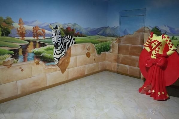 Un murale raffigurante una zebra, un costume rosso e dorato e un muro in pietra.
