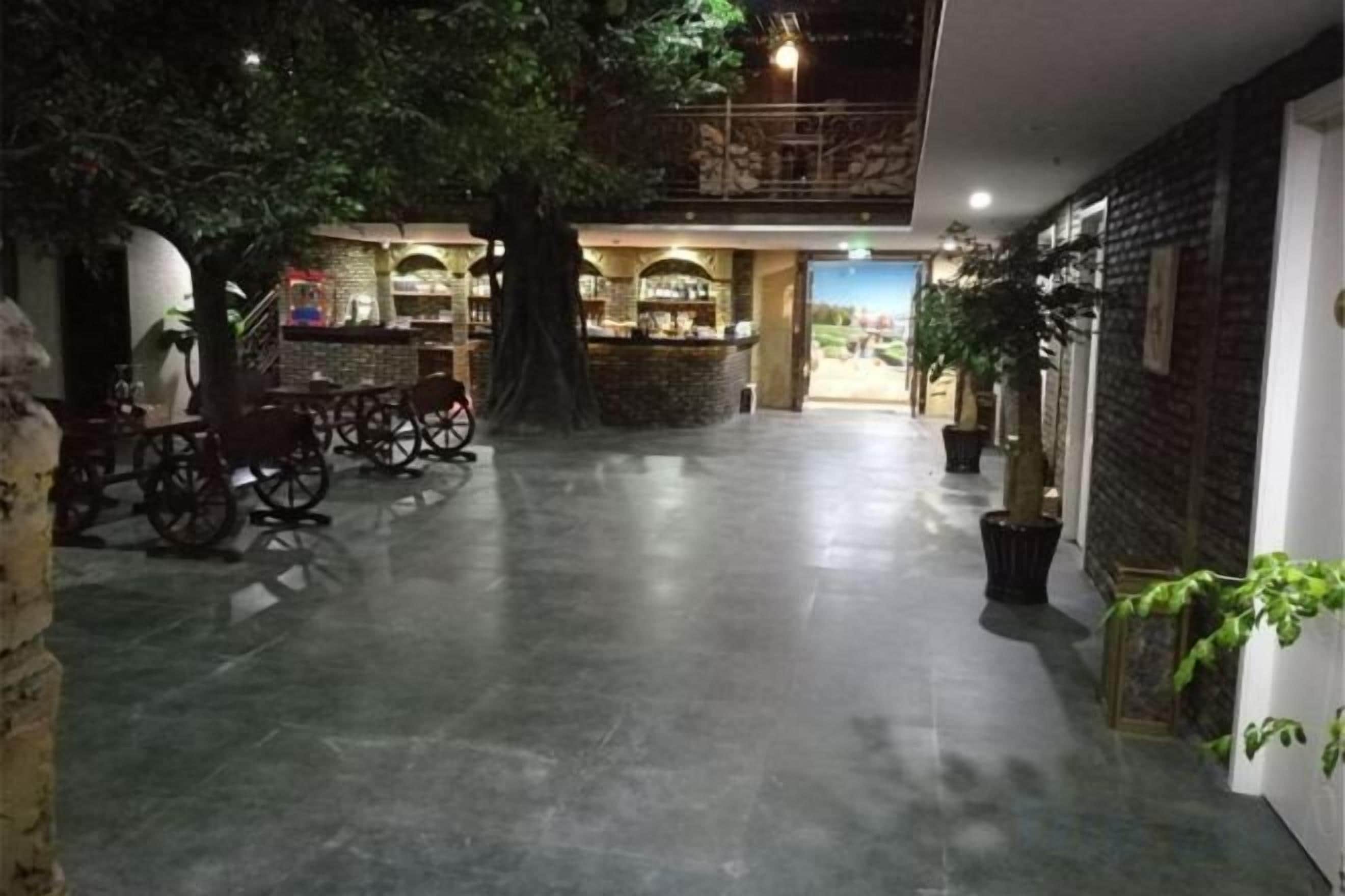A spacious indoor area with a bar, seating, and a tree.