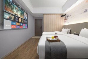 A hotel room with a large wall-mounted TV displaying movie posters, two beds with white bedding, a wooden floor, and a ceiling with recessed lighting. - Hyatt Regency Loudilai (Loudi)
