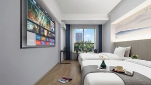 A hotel room with two beds, a large wall-mounted TV, a window with a view, and a small table with a vase and a cup. - Hyatt Regency Loudilai (Loudi)
