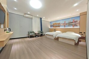 A hotel room with two beds, a desk, a chair, a small table, and a painting on the wall.