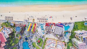 Vista aérea de um resort com várias piscinas, uma praia e diversas opções de lazer.