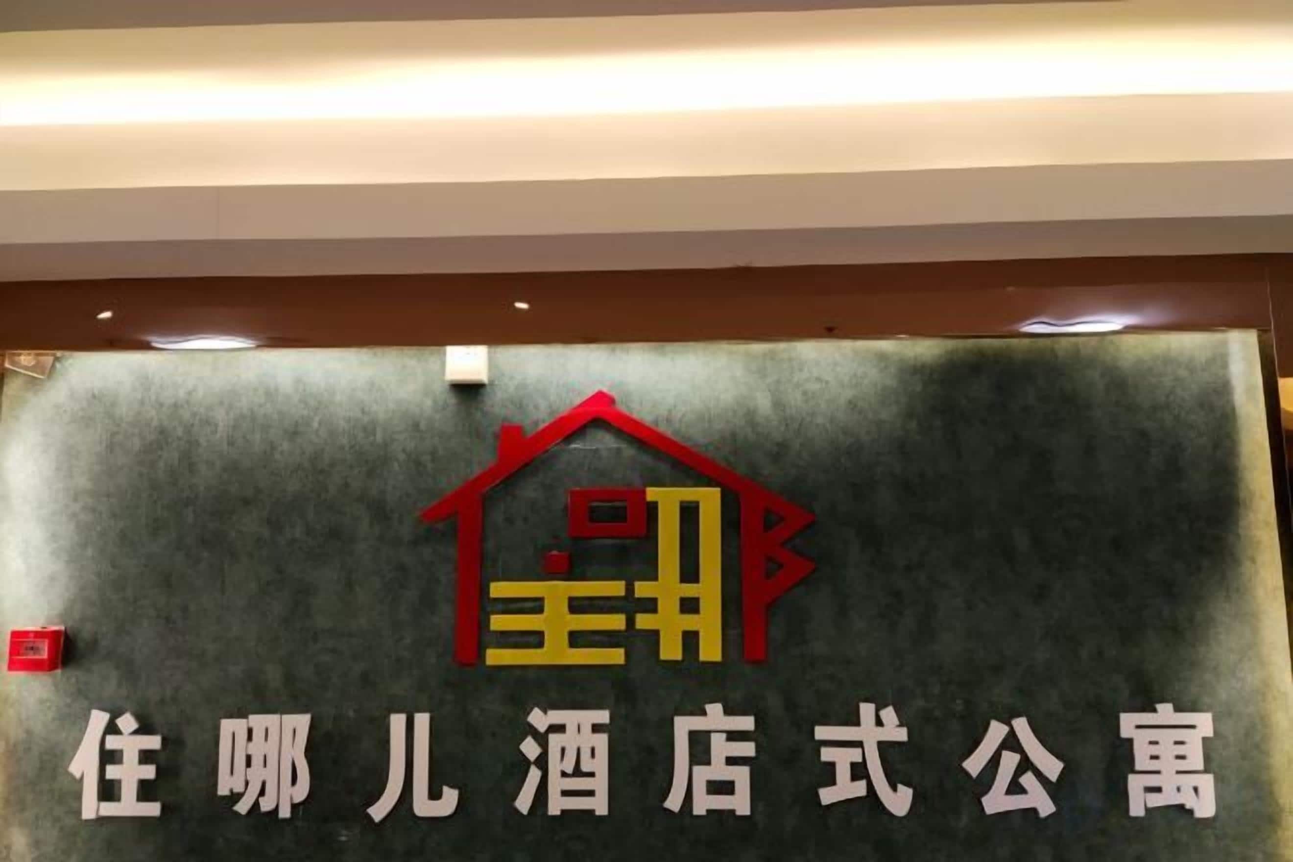 A sign with a house logo and text indicating a hotel-style apartment.