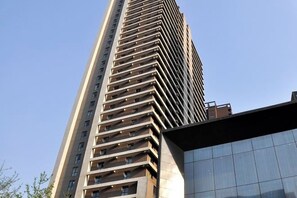 A tall building with a modern design, featuring multiple balconies and a glass facade. - Taiyuan Live Service Apartment (Taiyuan)