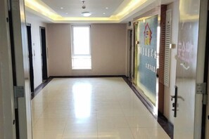 A hallway with a tiled floor, a window, and doors on both sides. - Taiyuan Live Service Apartment (Taiyuan)