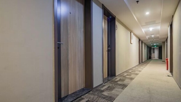 A long, narrow hallway with doors on one side and a carpeted floor. - Homeinn · neo (Chengdu Chunxi Road Taikoo Li Store) (Chengdu)