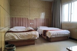 A hotel room with two beds, a tiled wall, a window with curtains, and a trash bin. - Guangdong Express Hotel, Zhangzhou (Bozhou)