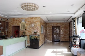 A hotel lobby with a reception desk, a fish tank, and a large mirror. - Guangdong Express Hotel, Zhangzhou (Bozhou)