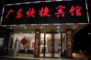 A hotel entrance with a neon sign, glass doors, and traditional Chinese decorations. - Guangdong Express Hotel, Zhangzhou (Bozhou)