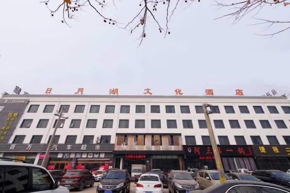 A multi-story building with a row of shops on the ground floor.