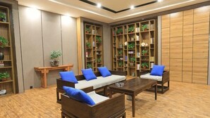 A room with a sofa set, a coffee table, and built-in bookshelves. - Riyue Lake Culture Hotel (Shangqiu)