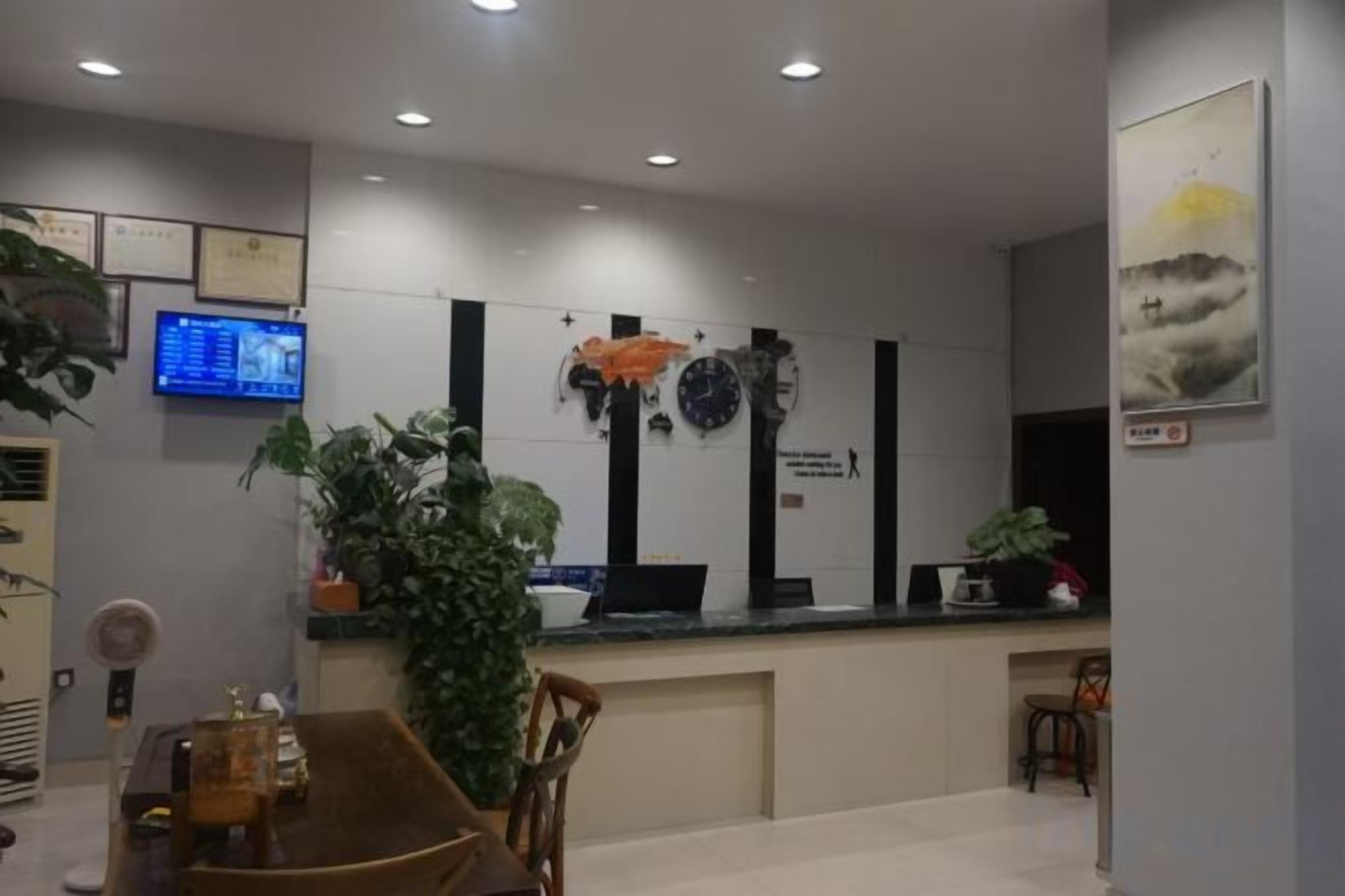 A reception area with a counter, chairs, a television, and wall decorations.