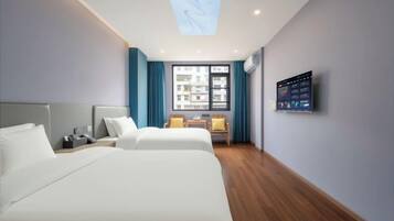 A hotel room with two beds, a desk, a chair, a TV, and a window with curtains.