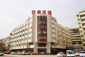 A multi-story hotel with a central entrance, several floors, and a parking area in front. - Lanzhou Fuxi Hotel (Lanzhou)