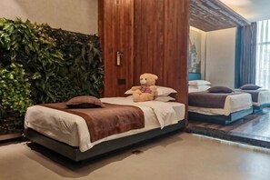 A hotel room with a bed, a teddy bear, a wooden wardrobe, and a green wall. - Mianyang 4D Future Hotel (Gaoshui Branch) (Mianyang)