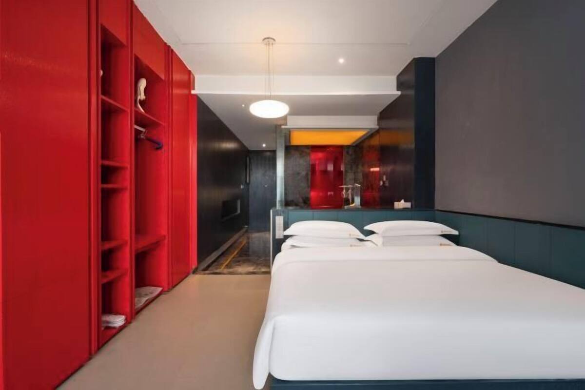 Ein Hotelzimmer mit einem Bett, einem roten Wandschrank und einem Spiegel.