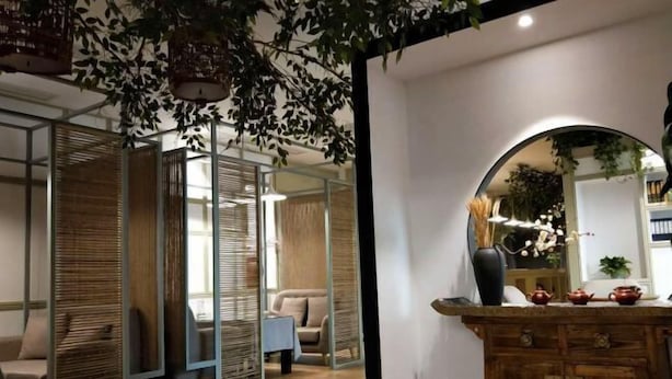 A modern interior with a wooden cabinet, a mirror, and a plant. - Mianyang 4D Future Hotel (Gaoshui Branch) (Mianyang)