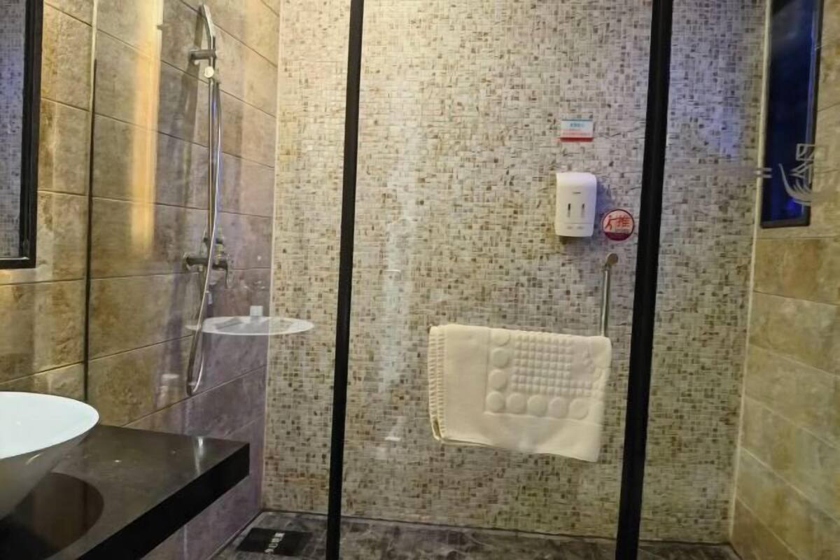 Ein Badezimmer mit Duschkabine aus Glas, Handtuchhalter und Waschbecken.