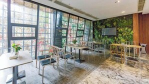 A modern restaurant with large windows, a green wall with plants, and a marble floor. - Mianyang 4D Future Hotel (Gaoshui Branch) (Mianyang)