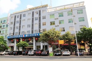 A multi-story building with a row of shops on the ground floor. - Time Inn (Wenchang)