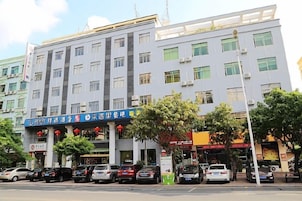 Un edificio de varios pisos con una fila de comercios en la planta baja.