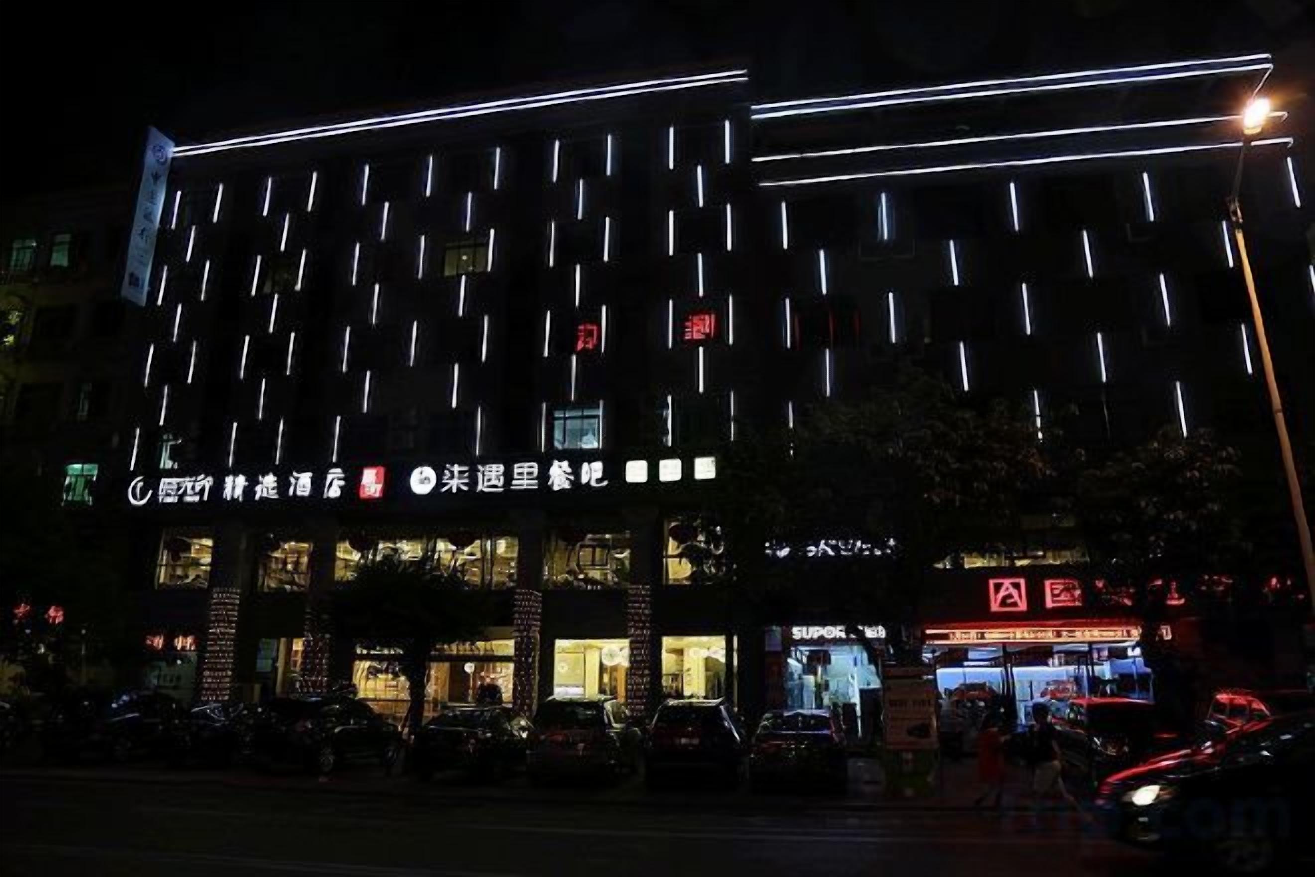 Un edificio con insegne illuminate e diversi ingressi.