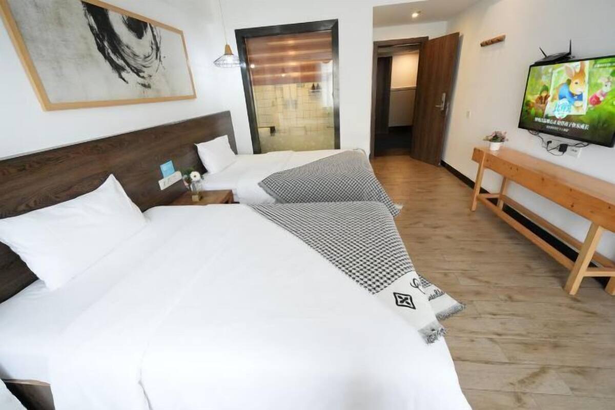 Habitació d'hotel amb un llit gran, una televisió, una panxa i una porta que dona a un bany.