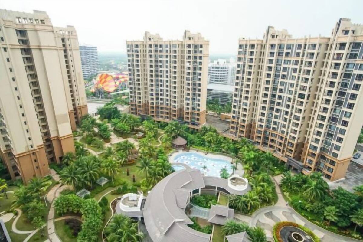 A high-rise residential building complex with multiple apartment buildings, a swimming pool, and landscaped gardens.