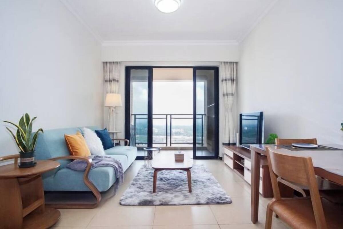 A modern living room with a sofa, coffee table, and dining area.