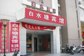 A hotel entrance with a red sign indicating the name and a banner for a fire drill. - Baishuitang Hotel (Jiashan)