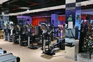 Un gimnasio con cintas de correr y equipo de ejercicio.