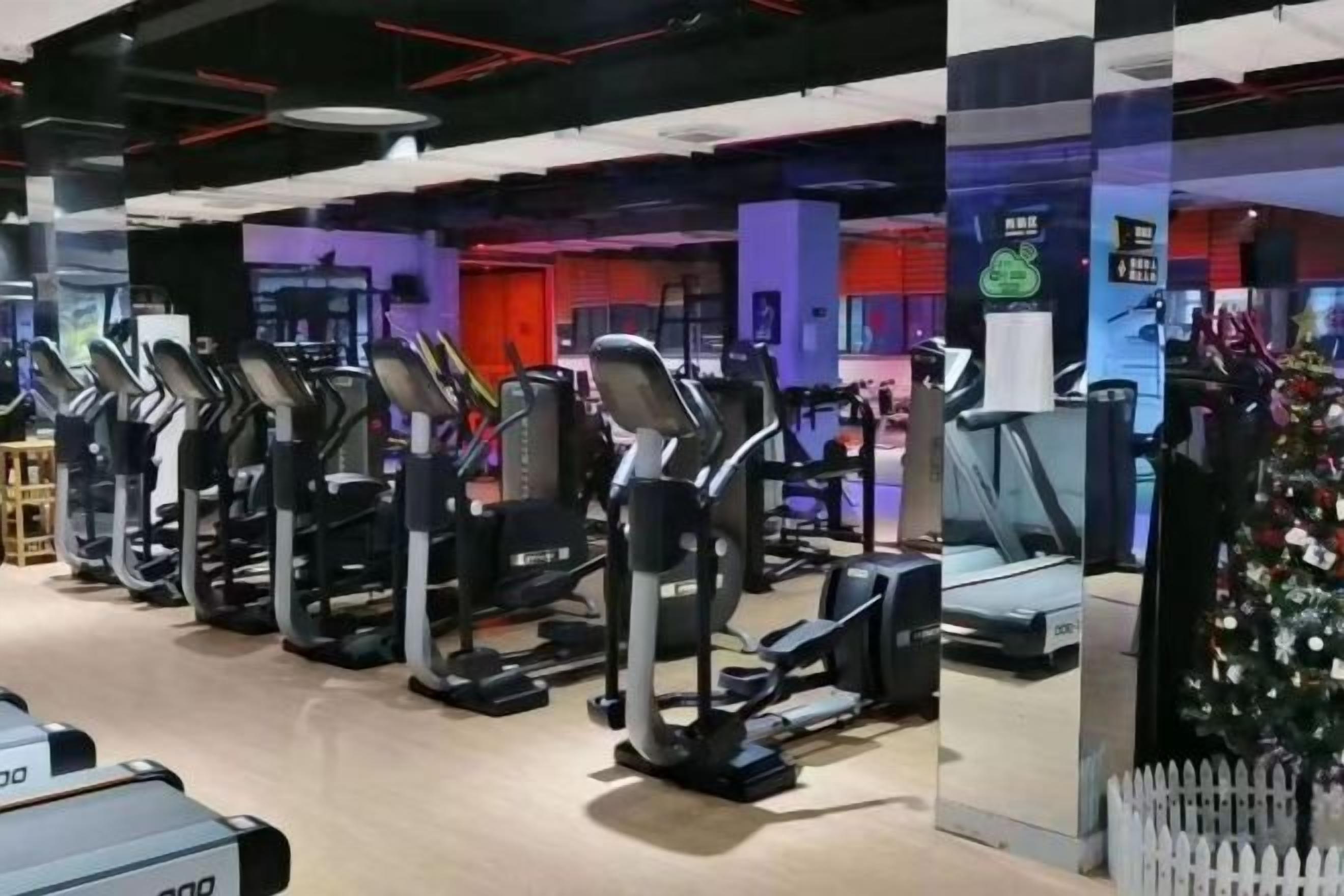 Een sportschool met loopbanden en fitnessapparatuur.