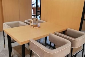 A dining area with a wooden table and four cushioned chairs. - Hotel of The Future (Jiefang Road) (Wulian)