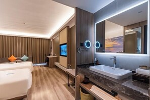 A modern hotel room with a large bed, a TV, a bathroom with a large mirror, and a wooden floor. - Hotel of The Future (Jiefang Road) (Wulian)