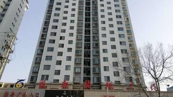 A high-rise building with multiple floors, featuring a commercial ground floor with signage.