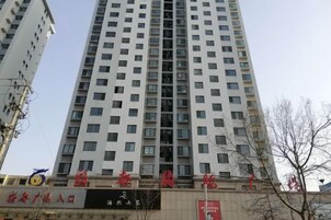 A high-rise building with multiple floors, featuring a commercial ground floor with signage.