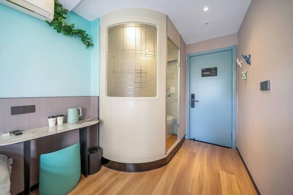 A modern bathroom with a curved mirror, a sink, and a toilet.