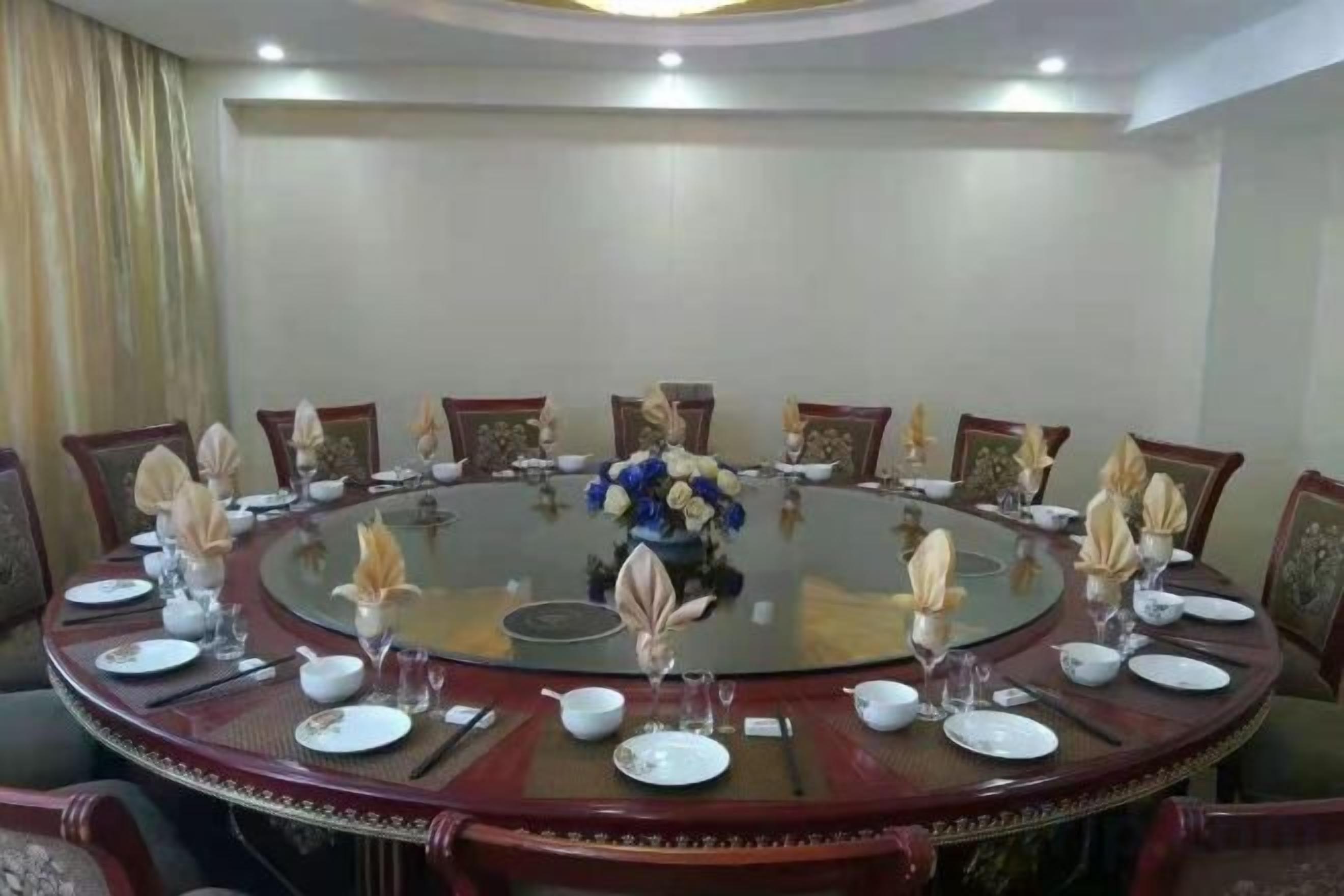 A conference room with a round table, chairs, and a central floral arrangement.