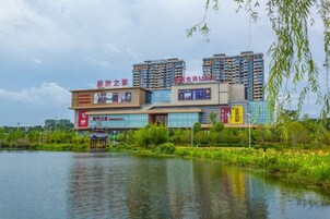Un edificio de varios pisos con locales comerciales en la planta baja, junto a una masa de agua.