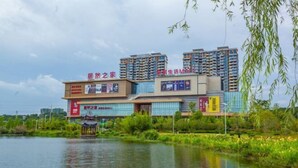A multi-story building with a modern design, featuring a large glass facade and several balconies. - New Beacon International Hotel (Luotian Tashanhu Park) (Luotian County)
