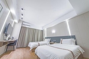 A hotel room with two beds, a desk with a chair, an air conditioning unit, and a window with curtains. - Shimao Haijing Guesthouse (Haikou)