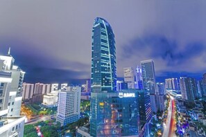 A cityscape with modern high-rise buildings, one prominently displaying a bank sign.