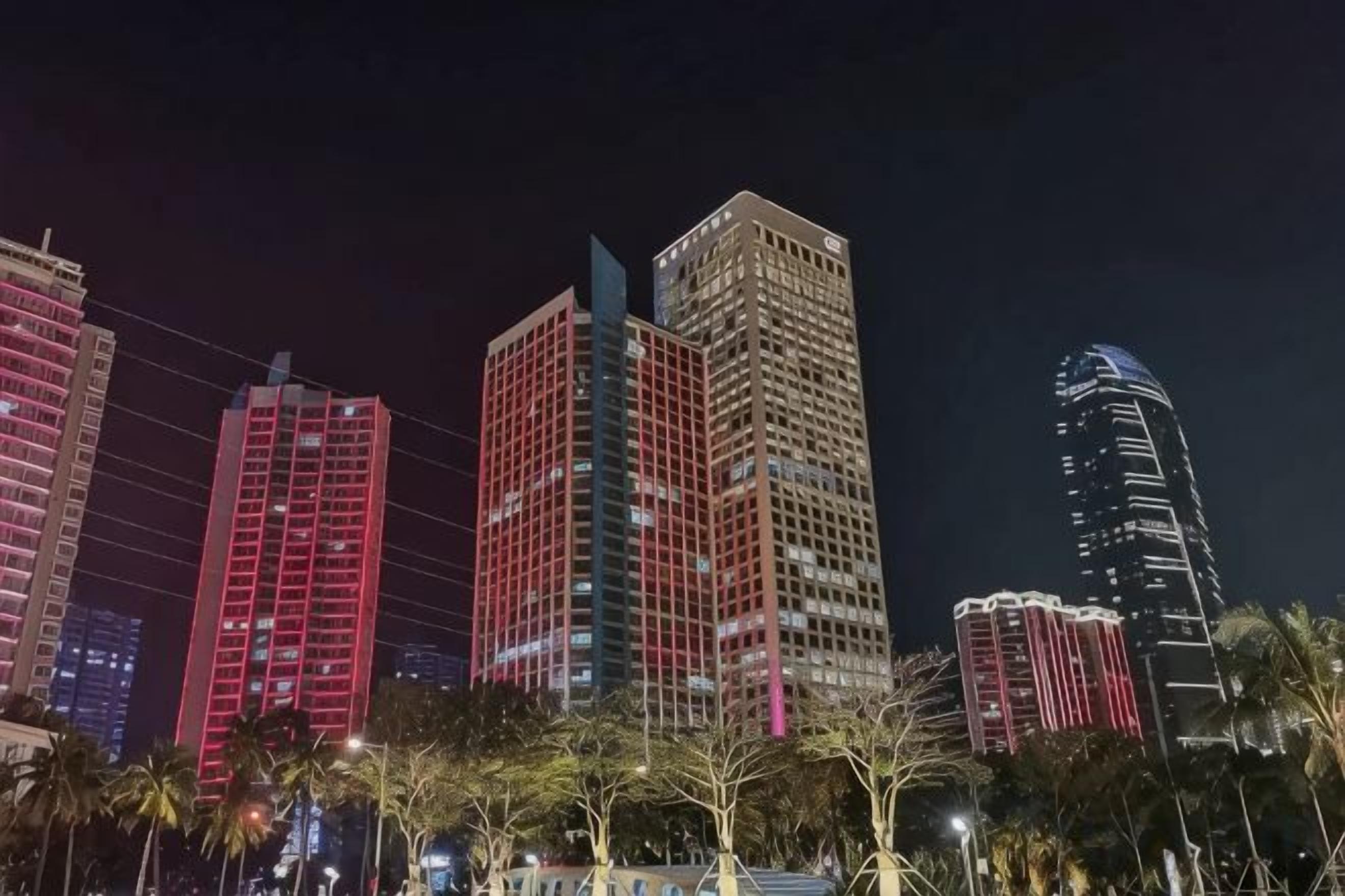 Un paisaje urbano nocturno con rascacielos iluminados.