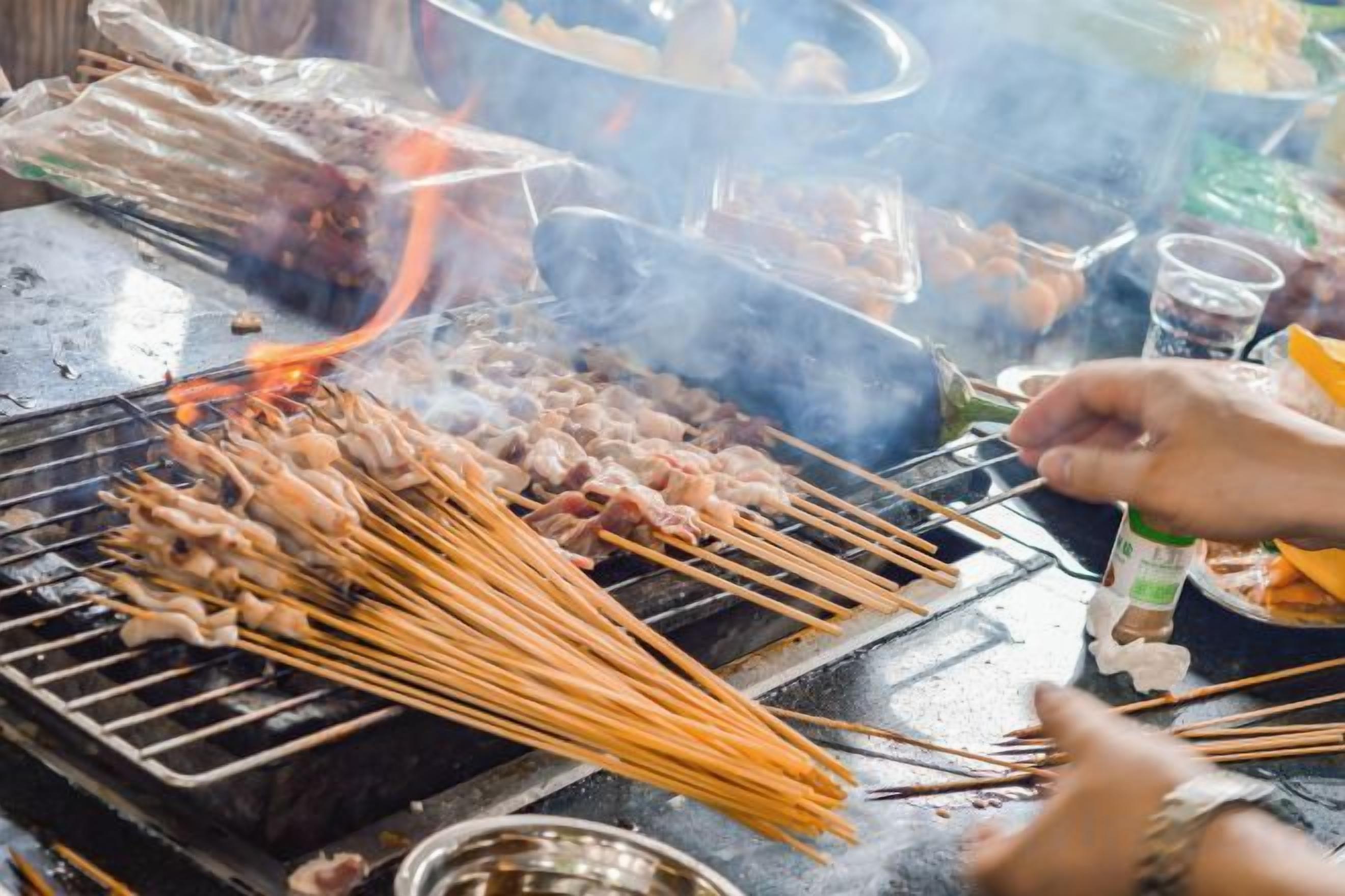 Een barbecue met spiezen eten boven een open vuur.