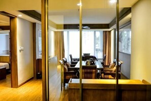 A hotel room with a dining area, a bed, and a view of the outdoors. - Green Field Manor (Ningbo)