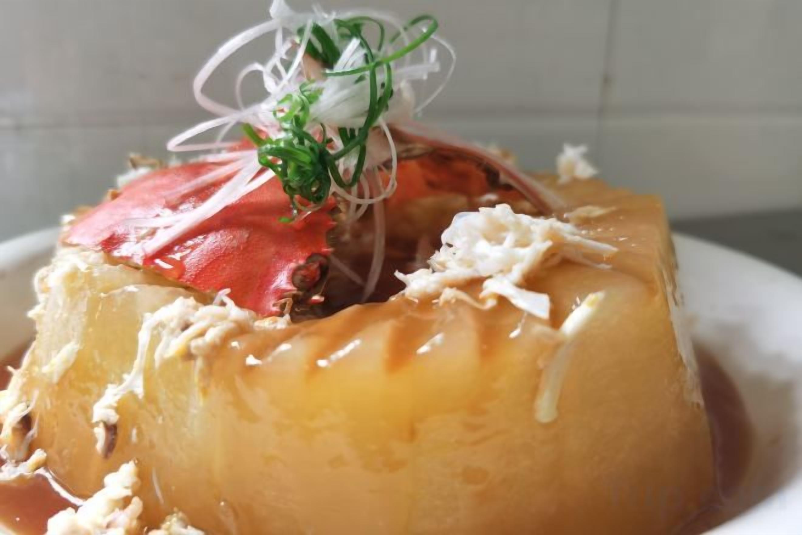 A dessert with a caramelized top, a fruit topping, and a decorative garnish.